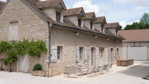 A stone building with multiple levels, a gravel driveway, and outdoor seating. - Charm Attitude building with swimming pool 5 * very close Beaune (Meursanges)