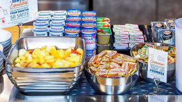 Un bufé de desayuno con diversas opciones de comida, incluyendo fruta, yogur y queso.