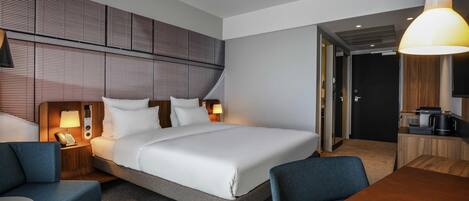 A hotel room with a bed, bedside tables, a desk, and a chair.