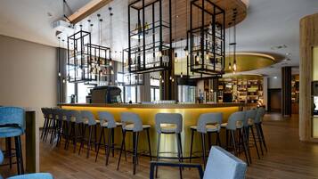 Eine moderne Bar mit einer zentralen Bar, verschiedenen Sitzgelegenheiten und einer Holzzieldecke.