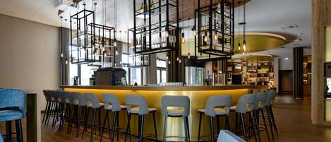 Zona de bar moderna con barra central, diversas opciones de asientos y techo de madera.
