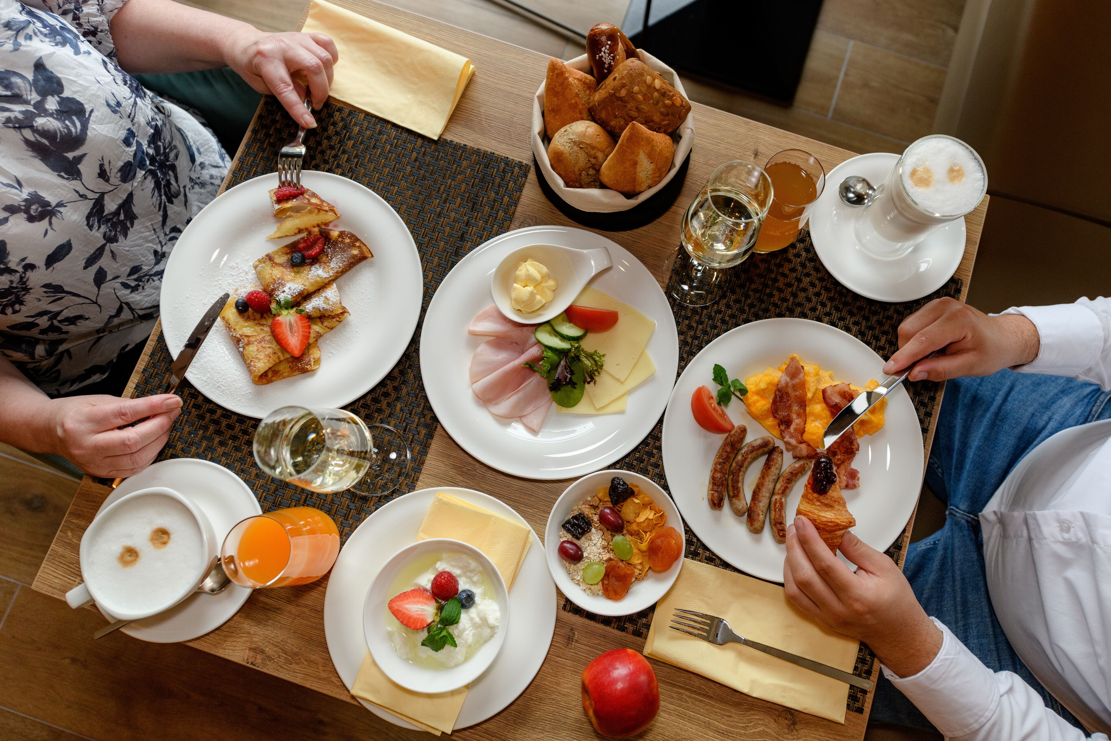 Ein Frühstückstisch mit verschiedenen Speisen, darunter Pfannkuchen, Eier und Toast.