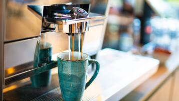 A coffee machine dispensing espresso into a blue cup.