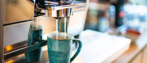 A coffee machine dispensing espresso into a blue cup.