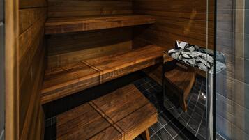 Una sauna con bancos de madera y puerta de cristal.
