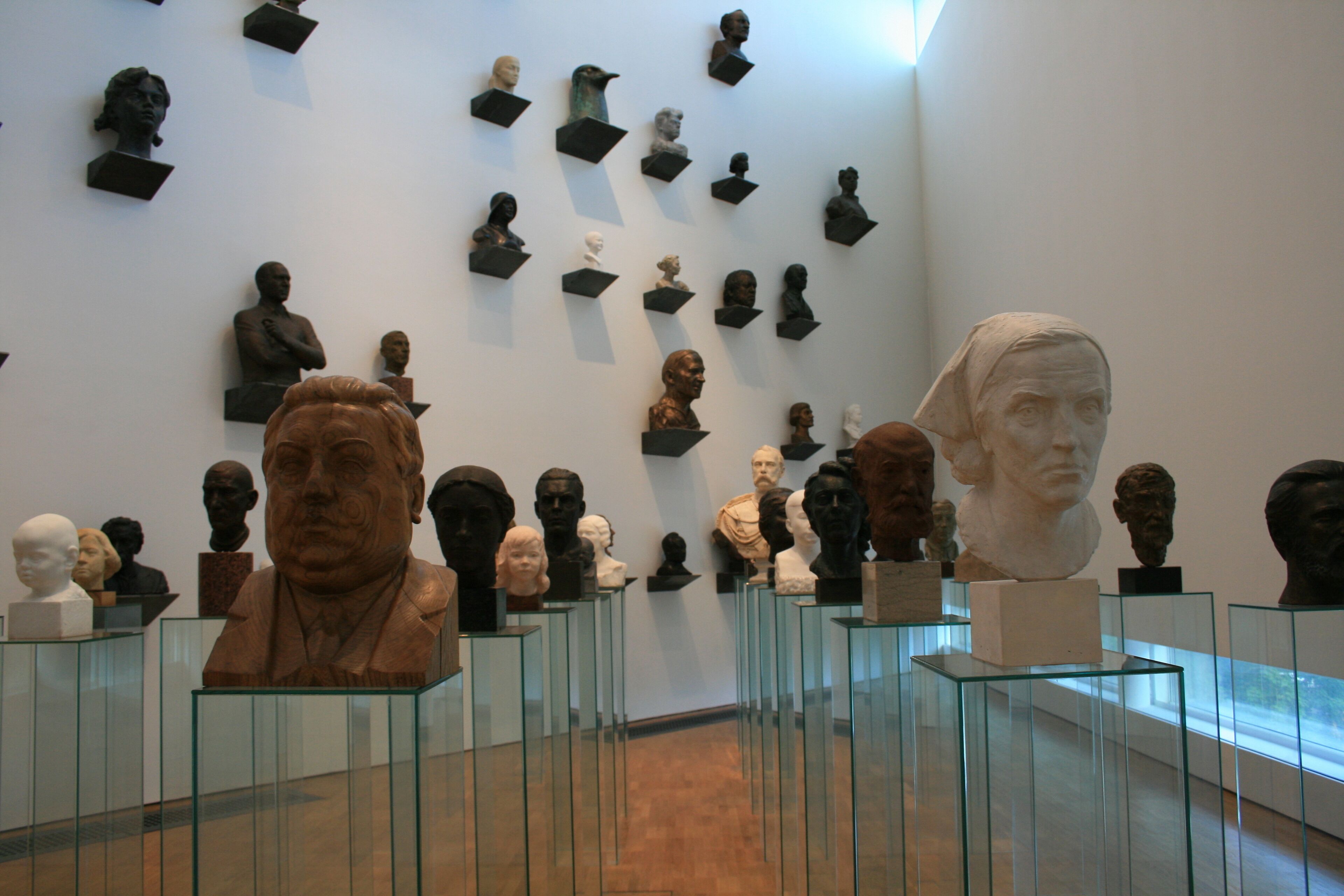A museum with glass display cases containing various sculptures.