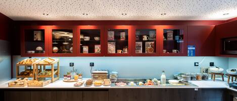 A breakfast bar with various food items and a coffee machine.
