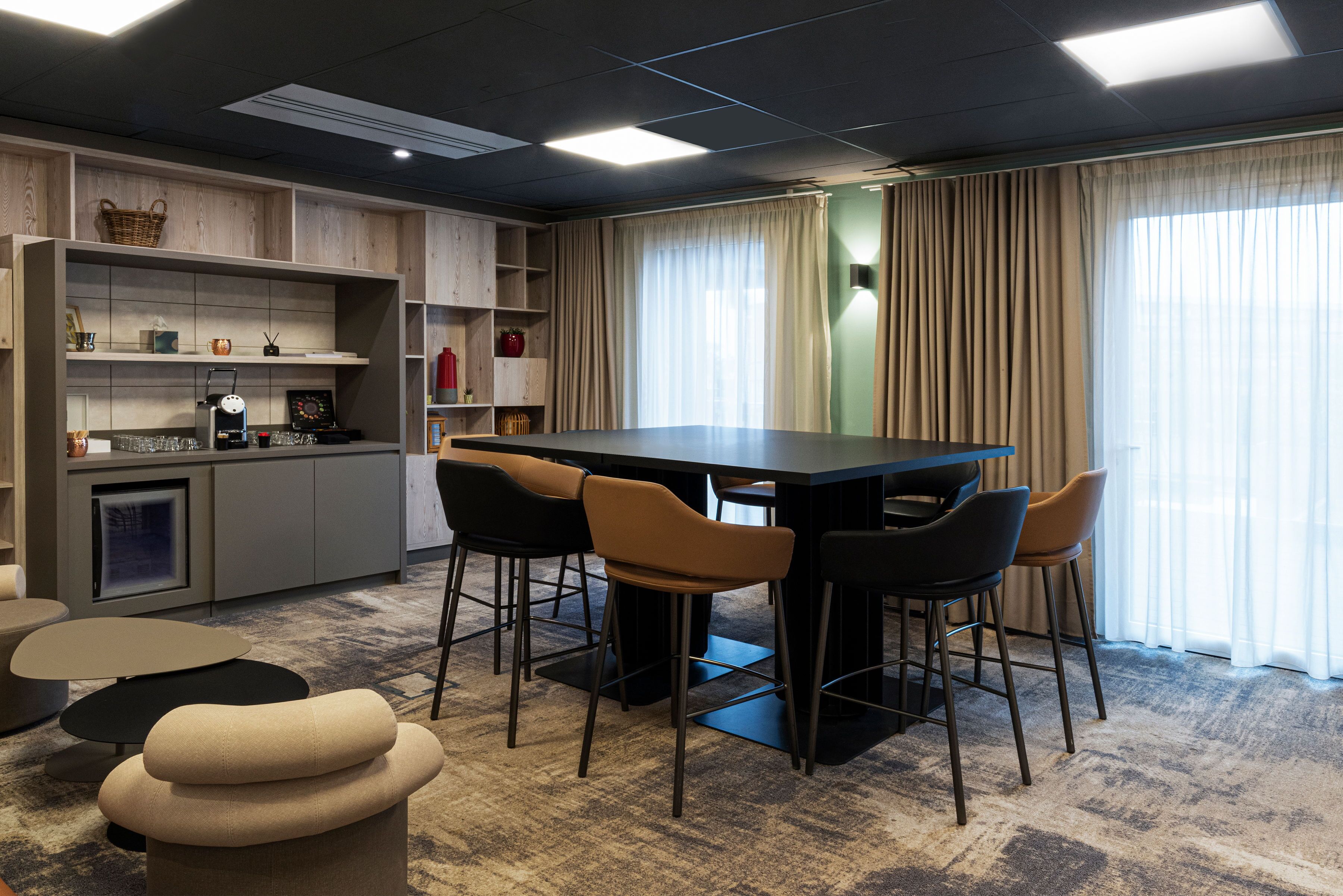 A modern dining area with a rectangular table, four chairs, and a kitchen area with shelves and appliances.