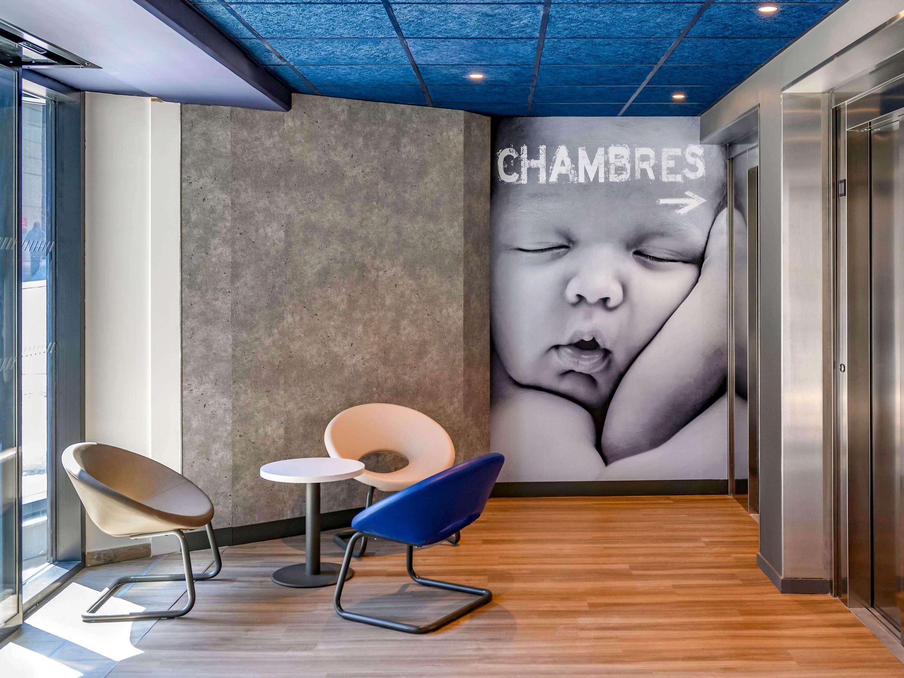 Un intérieur moderne avec un mur en béton, une fresque représentant un bébé et un plancher en bois.