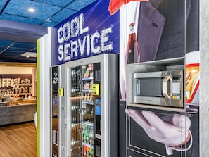 A vending machine area with a microwave and a sign that reads 'COOL SERVICE'. - Ibis Budget Saint-Etienne Centre Gare Châteaucreux (Saint-Etienne)