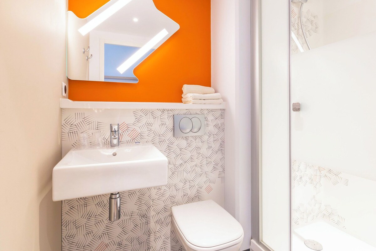Une salle de bain avec un lavabo blanc, des toilettes et une douche.