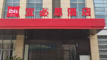 A hotel with a red awning and signage in a foreign language.