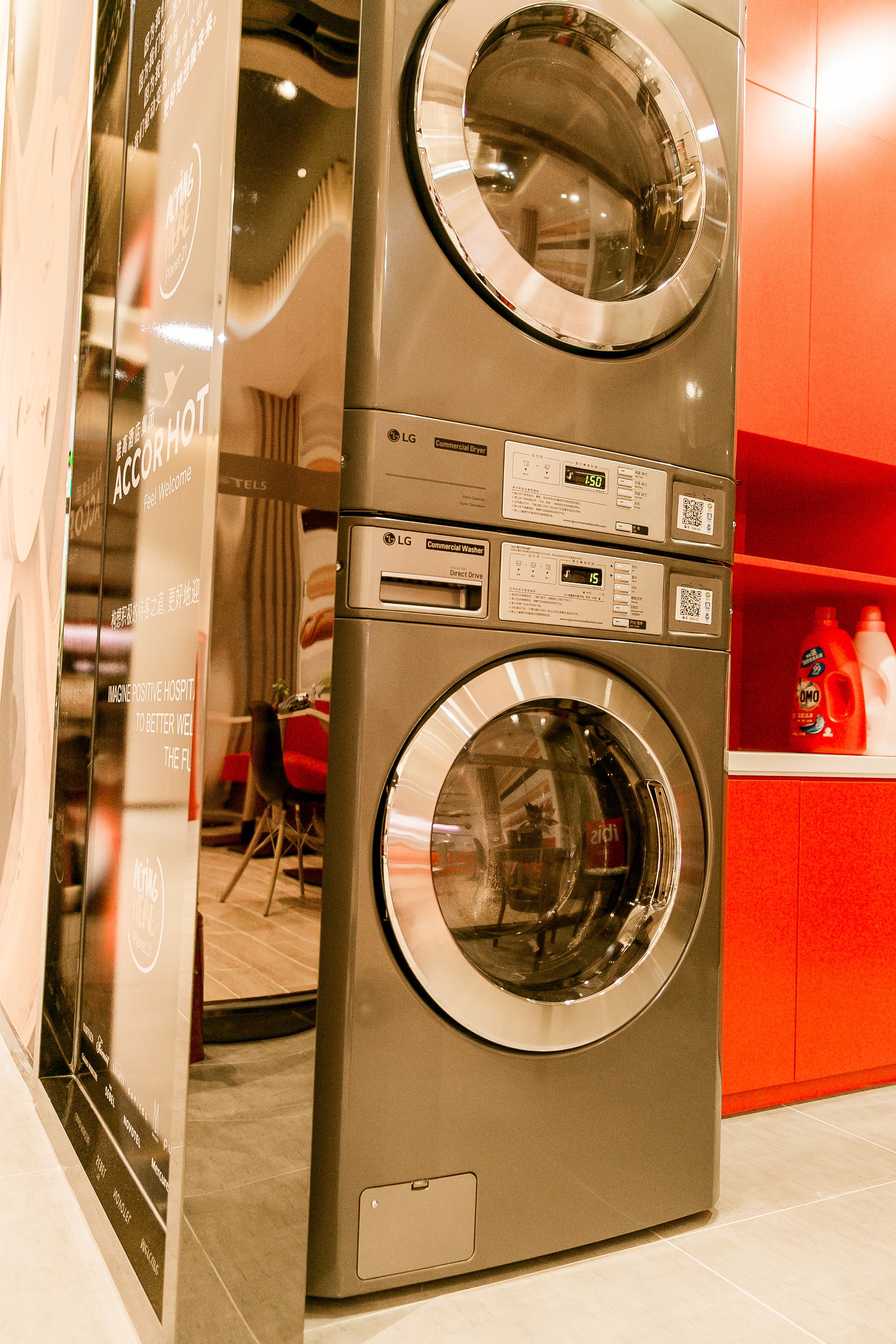 A stacked washer and dryer unit with control panels and a QR code.