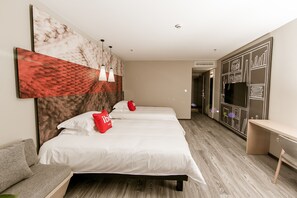 Ein Hotelzimmer mit Bett, Sofa, Schreibtisch und Kleiderschrank.