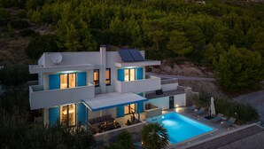 A modern two-story house with a swimming pool, solar panels, and a view of a mountainous landscape. - Villa Allegra with 32msq heated pool, 300m far from sandy beaches, open sea view (Duce)