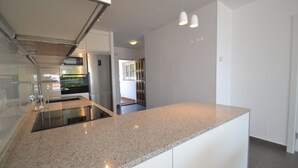 Una cocina moderna con encimeras de granito, electrodomésticos de acero inoxidable y armarios blancos.