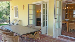 Un comedor con una mesa, sillas, un mueble de madera y vistas al exterior.