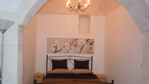 Un dormitorio con cama, candelabro y decoración en la pared.