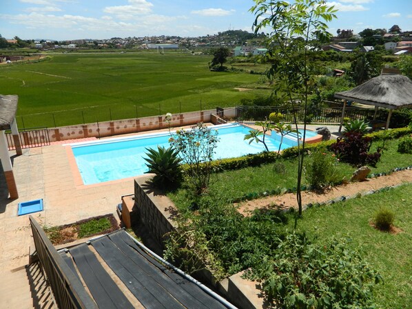 Una piscina al aire libre, camas de piscina gratis, sombrillas