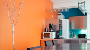 Una cocina moderna con comedor, que incluye una mesa grande, sillas y una escultura metálica original.