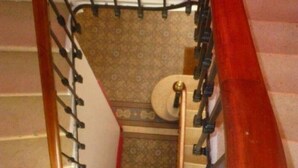 Una escalera de caracol con barandilla de madera y balaustres negros.