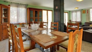 Un coin repas avec une table en bois, des chaises et un grand buffet.