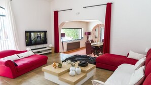 A modern living room with red sofas, a coffee table, and a TV. - Old barn renovated to nine  (BAGNOLS SUR CÈZE)