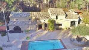A villa with a swimming pool, surrounded by trees and a hilly landscape. - Old barn renovated to nine  (BAGNOLS SUR CÈZE)