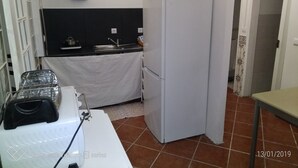 Eine kleine Küche mit einem weißen Kühlschrank, einer Spüle und einem Herd.