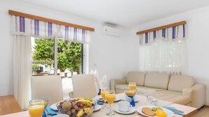 Un coin petit-déjeuner comprenant une table, des chaises, un canapé et une vue sur l’extérieur.