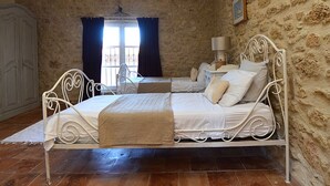 Un dormitorio con estructura de cama metálica, una mesita de noche con lámpara y un armario.