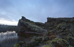 Eine zerklüftete Landschaft mit Felsformationen und einem Gewässer.