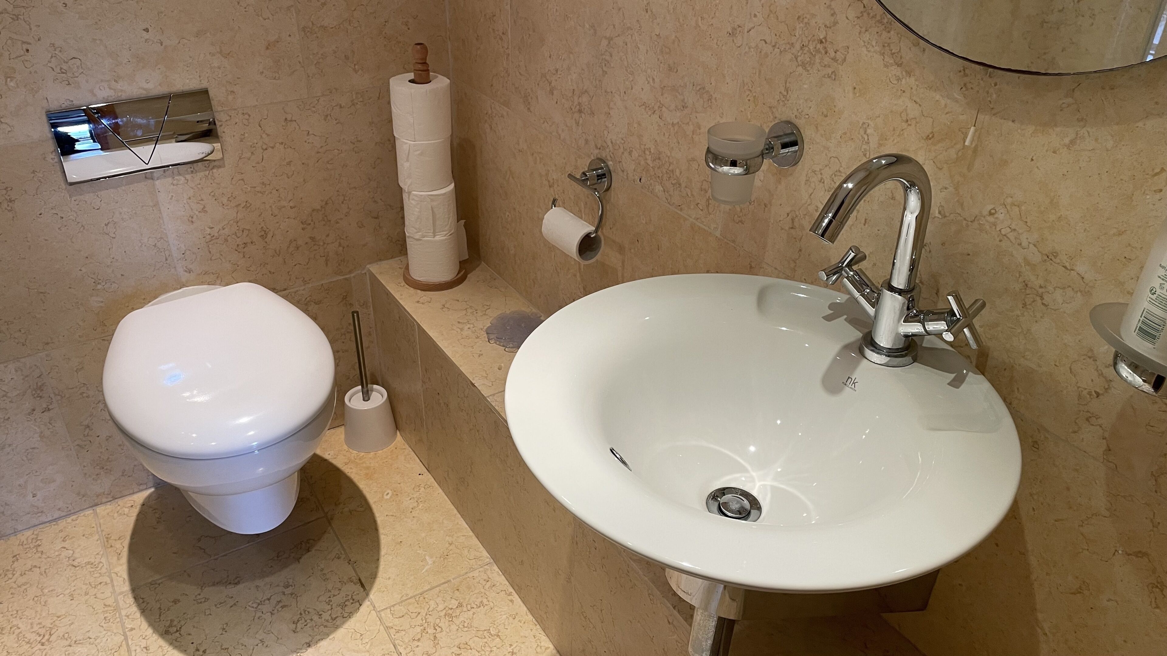 Un baño con inodoro, lavabo y dispensador de toallas.