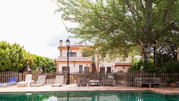 A pool area with lounge chairs and a wooden fence. - Accommodation with pool and paddle tennis court (Padul)