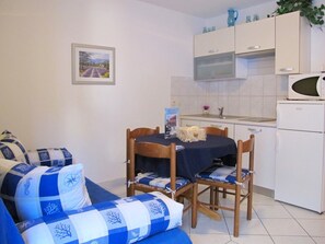 Een koelkast, een microgolfoven, kookgerei, borden en bestek