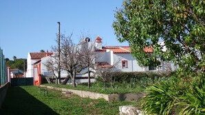 A white building with a red roof and a small window. There is a tree in front of the building and a fence on the left side. - Private villa with a plunge pool near the beach, featuring 2 large terraces and a hi-fi system (Lagos)