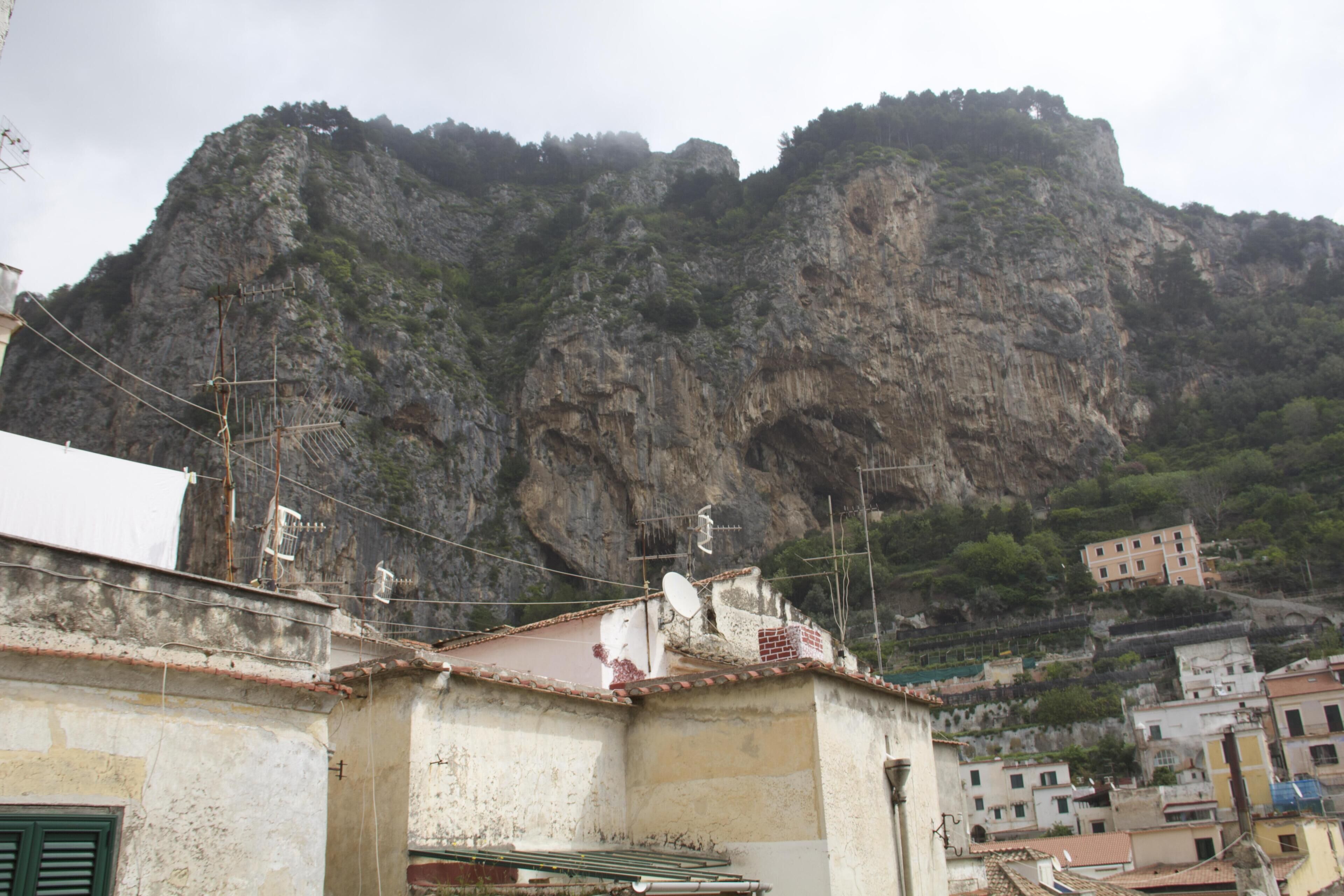 A coastal town with buildings close to a rocky cliff.