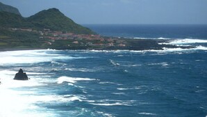 Uma vila costeira com vista para o mar e montanhas.