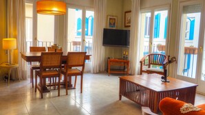 Un salon comprenant un coin repas, un téléviseur et un canapé.