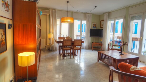 Un grand espace de vie comprenant une table à manger, des chaises, un canapé et un téléviseur.