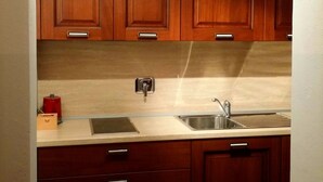A kitchen with wooden cabinets, a stainless steel sink, and a built-in oven. - Chalet with a beautiful view to comfortably enjoy nature in the Park and Valley (Introd)