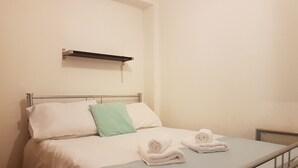 A neatly made bed with white and green pillows, a metal headboard, and a metal bed frame. - Rhodos 8 - 1 bedroom apartment 42m2 next to Grand Massif Express lift - NO WIFI (Samoëns)