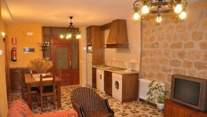 A compact living space with a dining area, kitchenette, and a television. - Casa Rural Bocanegra for 2 people (Canicosa de la Sierra)