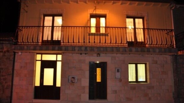 A two-story building with a balcony, a door, and windows. - Casa Rural Bocanegra for 2 people (Canicosa de la Sierra)