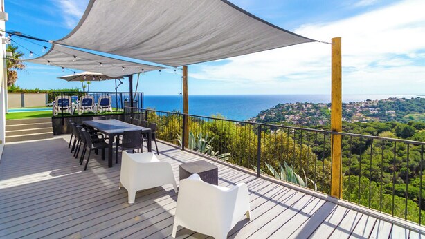 A deck with a table and chairs, overlooking a coastal landscape. - Club Villamar - A beautiful modern Apartment with private pool and free Wi-Fi, with a view of the... (Lloret de Mar)