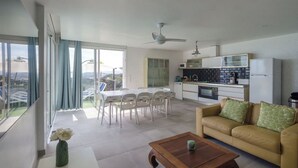 A modern living room with a sofa, coffee table, and dining area. There is a kitchen with appliances and a balcony with a view. - Club Villamar - A beautiful modern Apartment with private pool and free Wi-Fi, with a view of the... (Lloret de Mar)