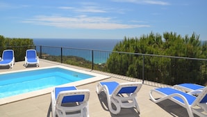 A pool area with lounge chairs and a view of the sea. - Club Villamar - A beautiful modern Apartment with private pool and free Wi-Fi, with a view of the... (Lloret de Mar)