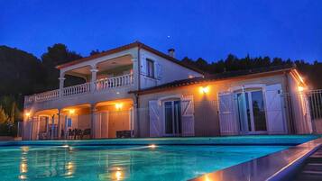 Een verwarmd zwembad en ligstoelen