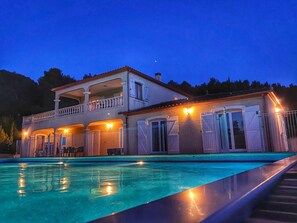 Una casa de dos pisos con una piscina al frente.