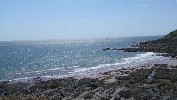A rocky coastline with clear blue water and a distant horizon. - Gower coast bungalow (Swansea City)